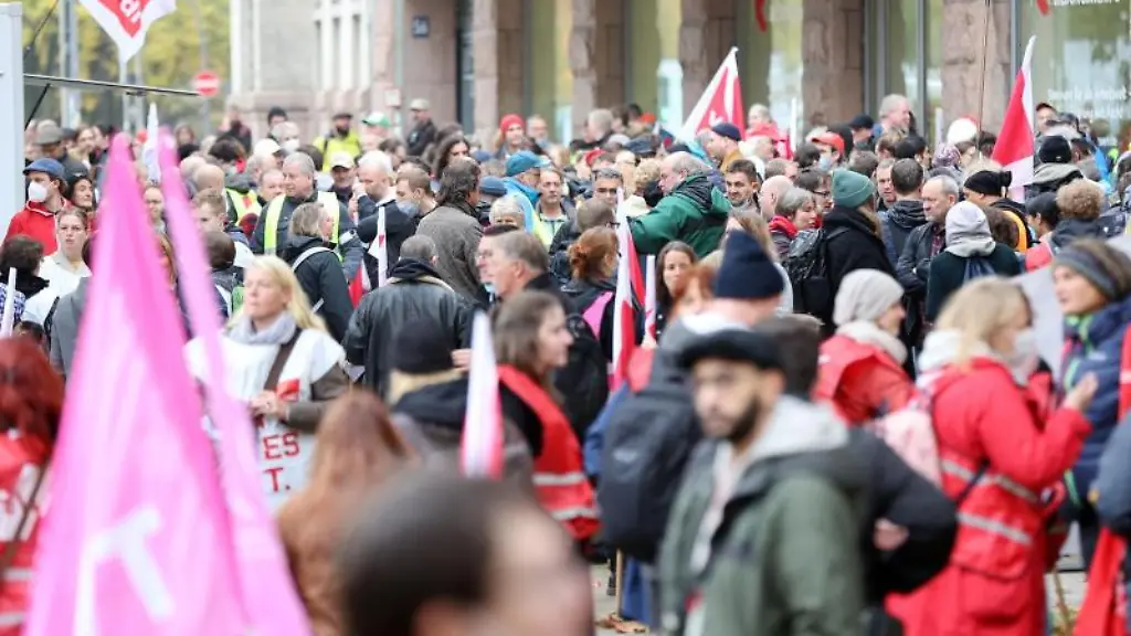 Teilnehmerinnen-und-Teilnehmer-stehen-bei-einer-Kundgebung-im-Rahmen-eines-Warnstreiks