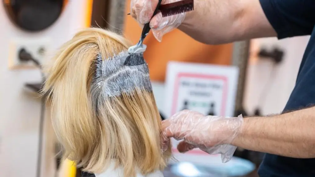 Ein-Friseur-faerbt-einer-Kundin-die-Haare