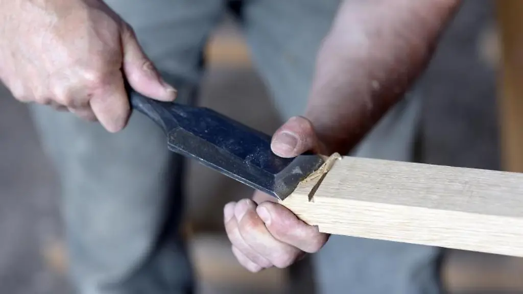 Ein-Tischer-arbeitet-in-seiner-Werkstatt-an-einem-Werkstueck