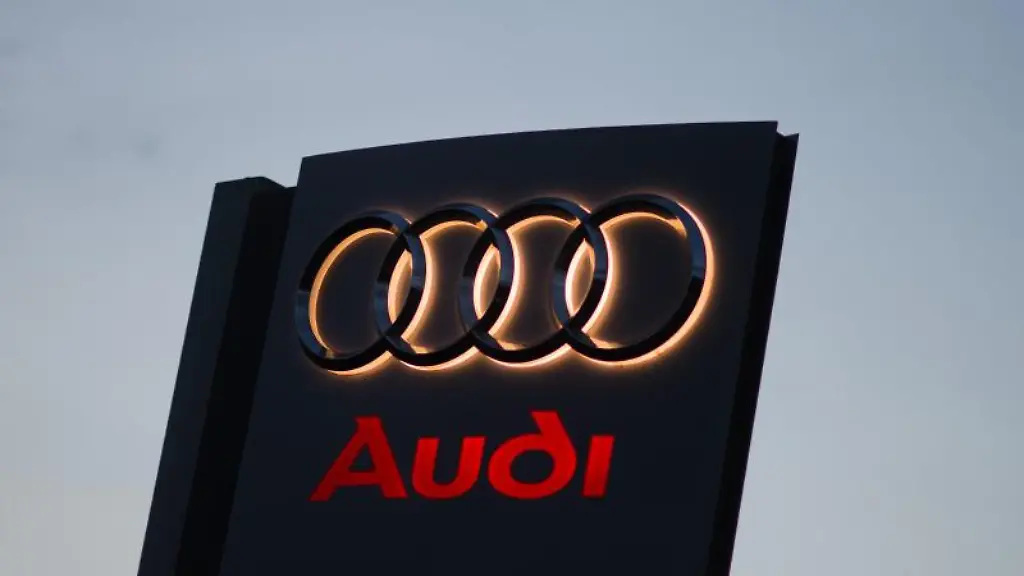 Ein-Audi-Logo-leuchtet-in-der-Morgendaemmerung-an-einem-Autohaus