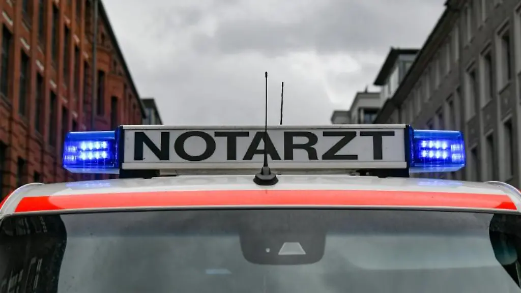 Ein-Notarztwagen-steht-mit-eingeschaltetem-Blaulicht-auf-der-Strasse