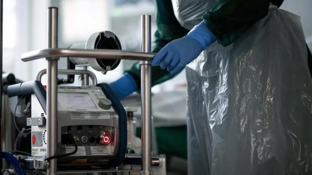 Eine-Mitarbeiterin-der-Pflege-steht-in-einem-Zimmer-einer-Corona-Intensivstation