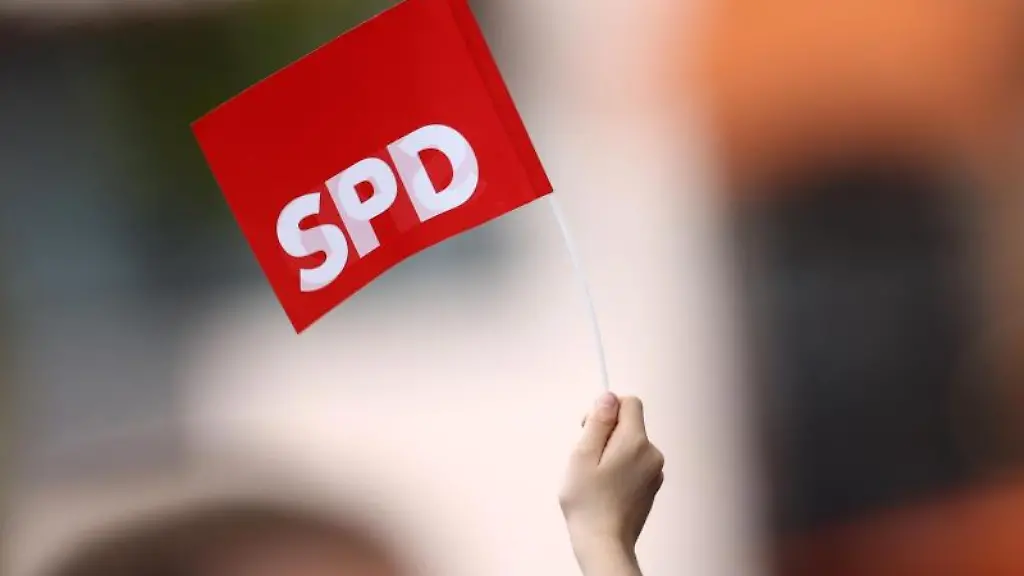 Ein-Mann-haelt-bei-einer-Wahlkampfveranstaltung-eine-SPD-Fahne-hoch