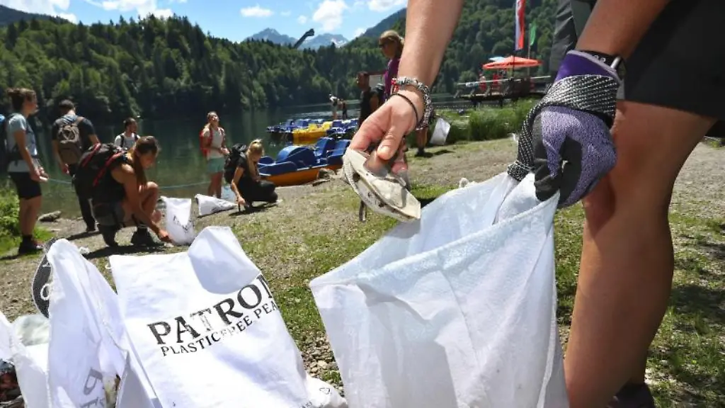 Eine-Gruppe-von-Freiwilligen-sammelt-Muell-am-Ufer-des-Freibergsees