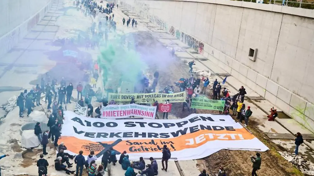 Klimaaktivisten-unterschiedlicher-Buendnisse-gehen-ueber-die-Baustelle-der-A100