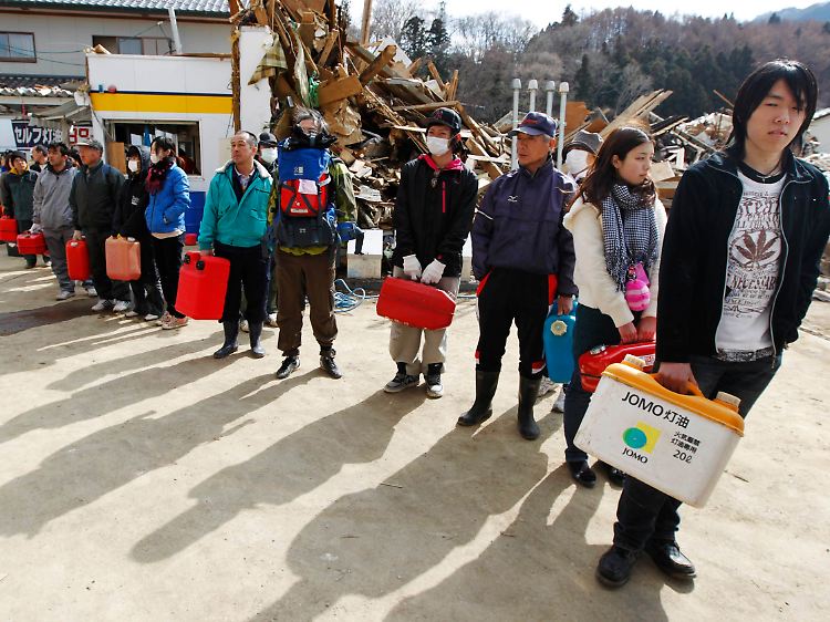 Japaner stellen sich nach dem Tsunami an einer Tankstelle an, um Treibstoff zu kaufen.