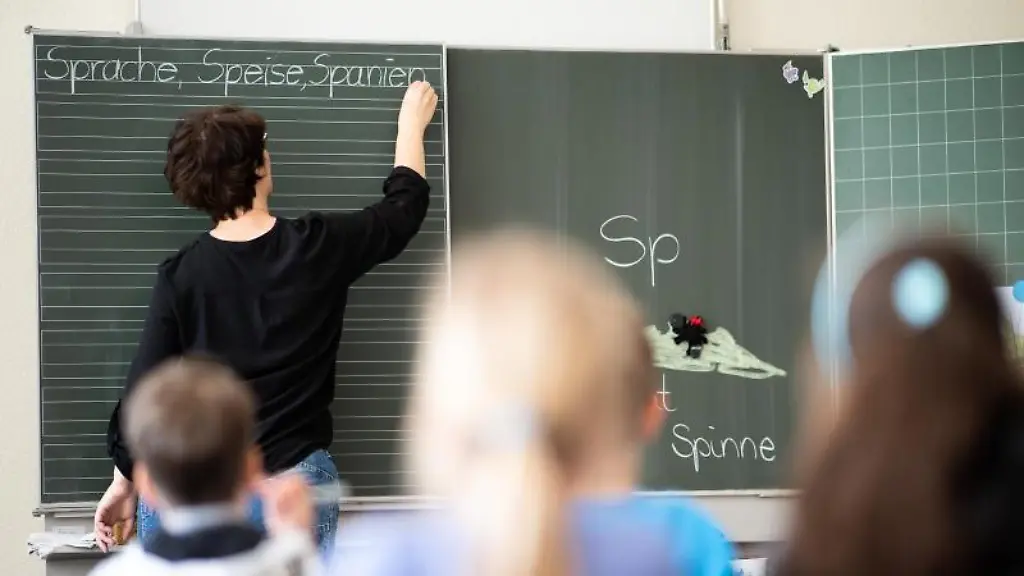Eine-Lehrerin-schreibt-in-einer-Schule-an-die-Tafel