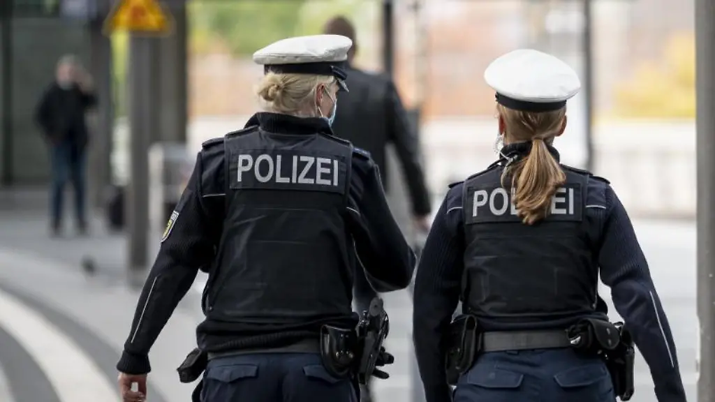 Zwei-Polizistinnen-patroullieren-auf-dem-Bahnsteig-eines-Bahnhofs