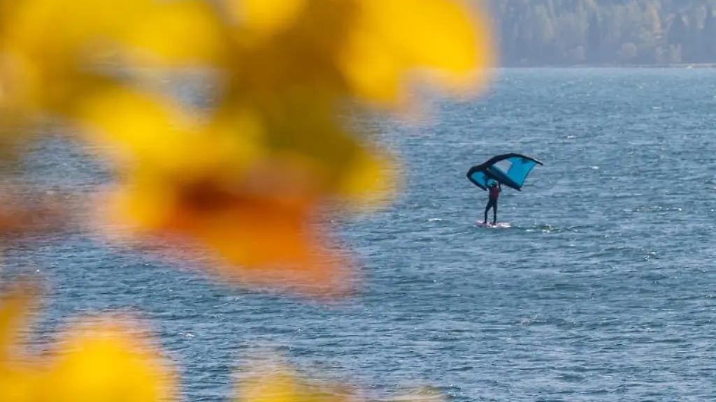 Ein-Windsurfer-gleitet-mit-seinem-Freizeitsportgeraet-ueber-das-Wasser