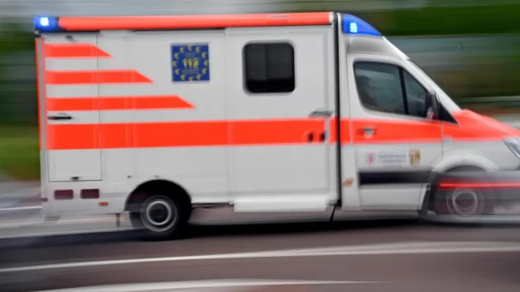 Ein-Krankenwagen-faehrt-mit-Blaulicht-auf-einer-Strasse