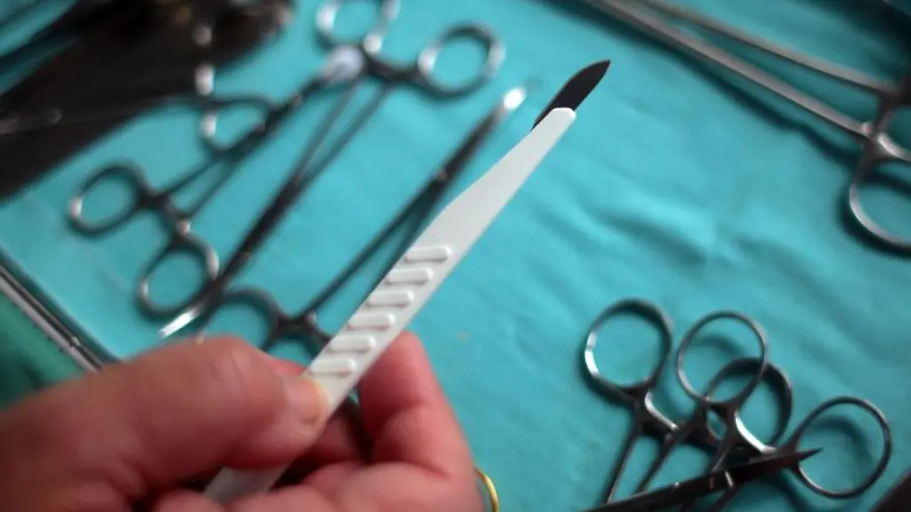 Ein-Chirurg-haelt-im-OP-ein-Skalpell-in-der-Hand