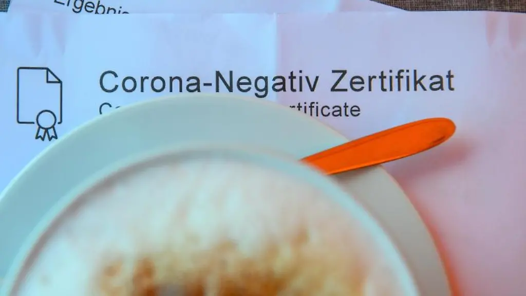 Ein-Milchkaffee-steht-in-einem-Cafe-auf-einem-Tisch-auf-einem-Corona-Negativ-Zertifikat
