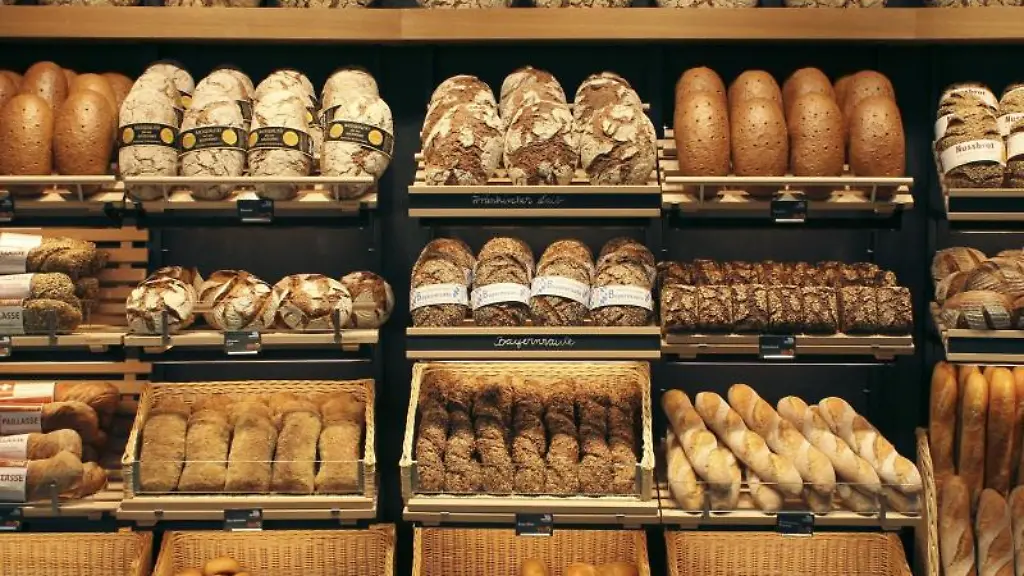 Brote-verschiedenster-Sorten-liegen-in-Koerben-und-auf-Regalen