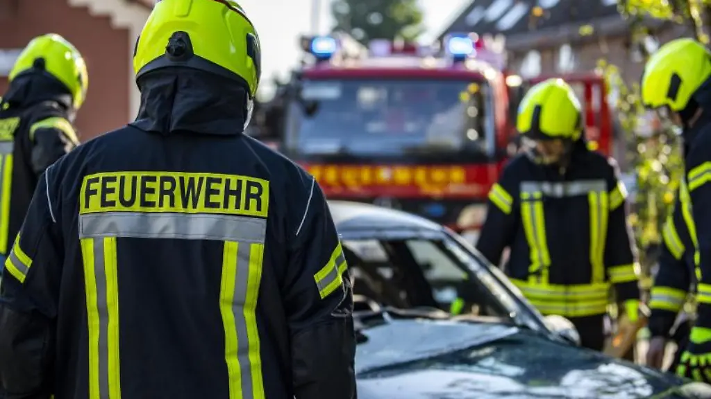 Feuerwehrleute-stehen-um-ein-Auto-das-einen-Unfall-gehabt-hat
