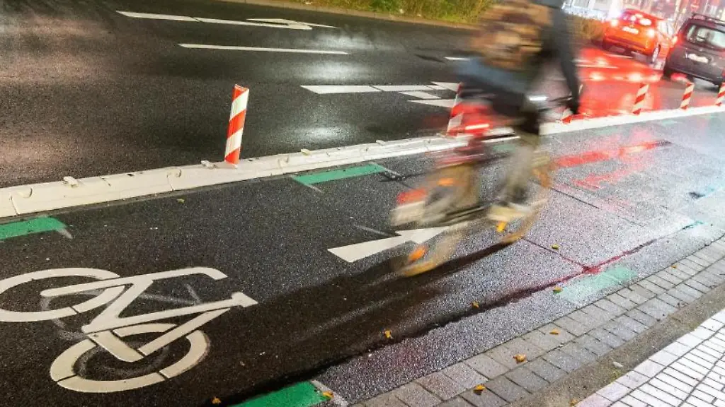 Ein-Mann-faehrt-mit-einem-Fahrrad-am-fruehen-Morgen-ueber-die-Veloroute-in-die-Innenstadt-von-Hannover