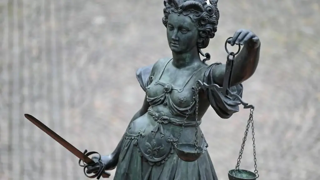 Eine-Statue-der-Justitia-haelt-eine-Waage-und-ein-Schwert-in-der-Hand