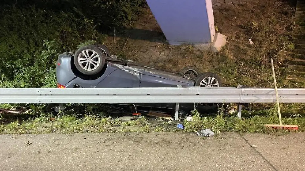 Ein-verunfallter-PKW-liegt-hinter-einer-Leitplanke-an-der-Unfallstelle
