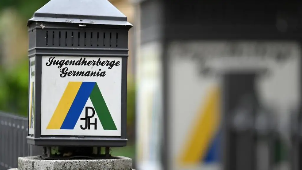 Eine-Laterne-mit-der-Aufschrift-Jugendherberge-Germania-steht-vor-einem-Haus