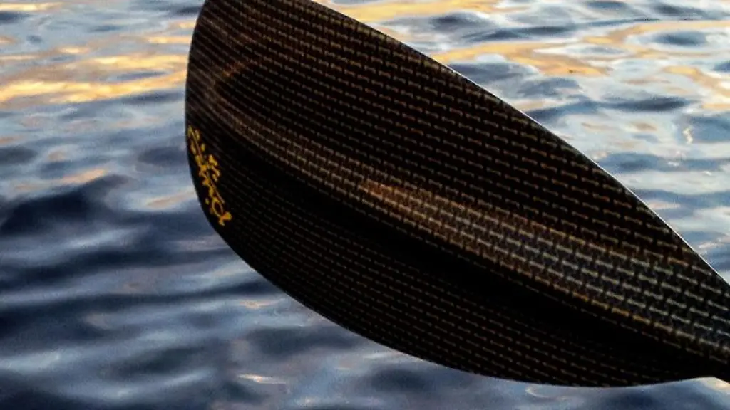 Von-einem-Paddel-faellt-ein-Wassertropfen-auf-die-Wasseroberflaeche