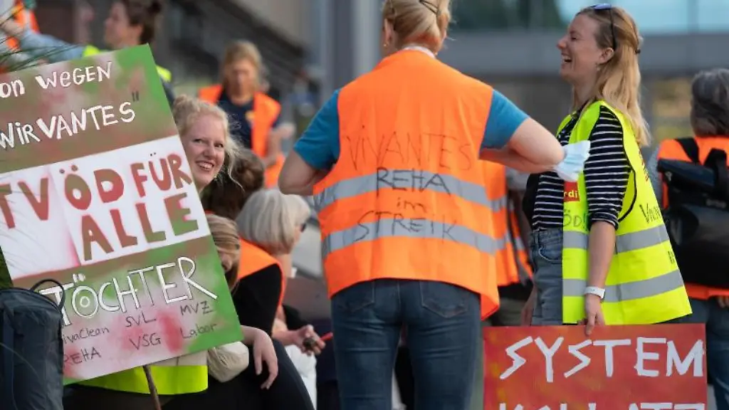 Teilnehmer-an-einer-Demonstration-stehen-vor-einem-Hochhaus