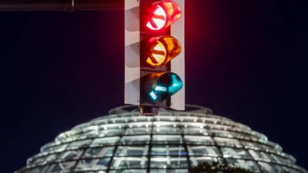 Eine-Ampel-vor-der-Kuppel-des-Reichstagsgebaeudes-leuchtet-in-allen-drei-Phasen