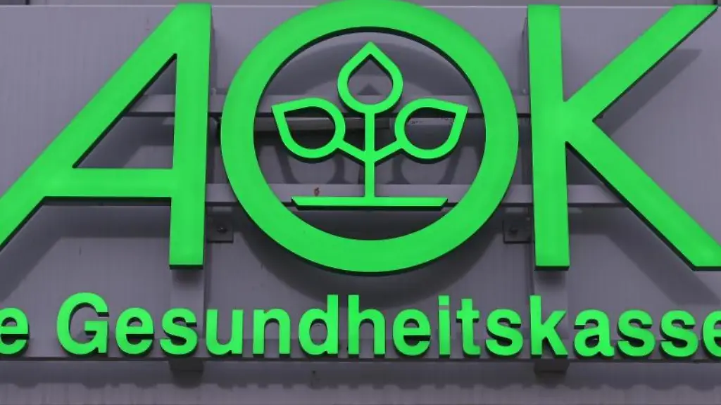 Das-Logo-der-AOK-ist-an-einem-Gebaeude-zu-sehen