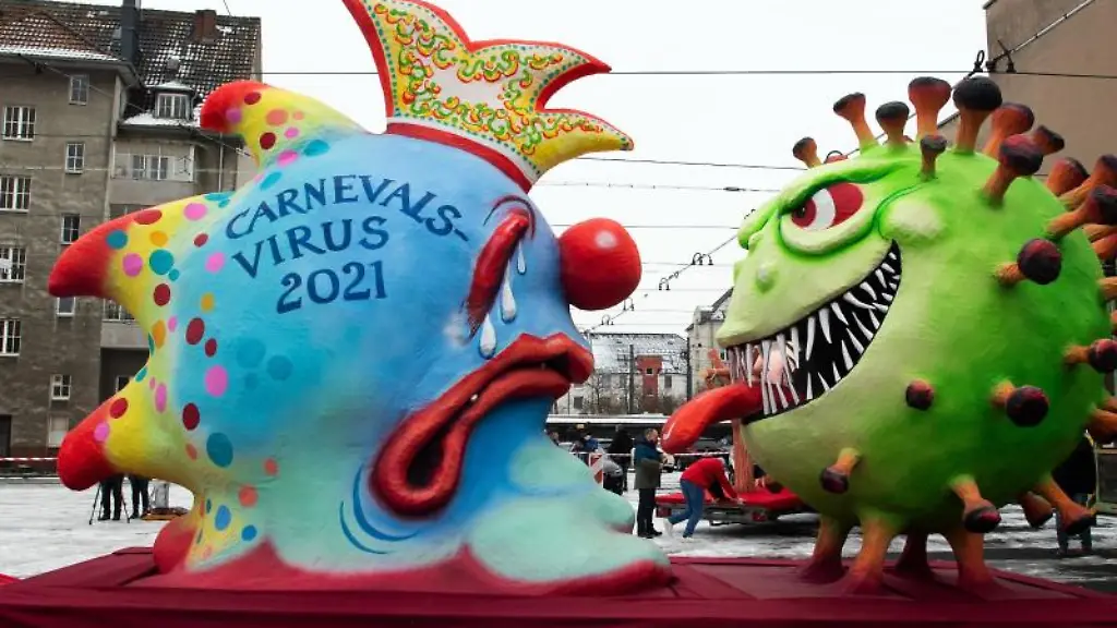 Ein-Mottowagen-auf-dem-das-Coronavirus-dem-Carnevalsvirus-die-Zuge-rausstreckt