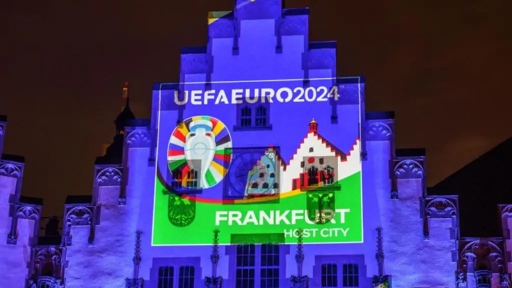 Der-Frankfurter-Roemer-ist-am-Abend-mit-Turnierlogo-des-Spielorts-Frankfurt-zur-naechsten-Fussball-Europameisterschaft-illuminiert