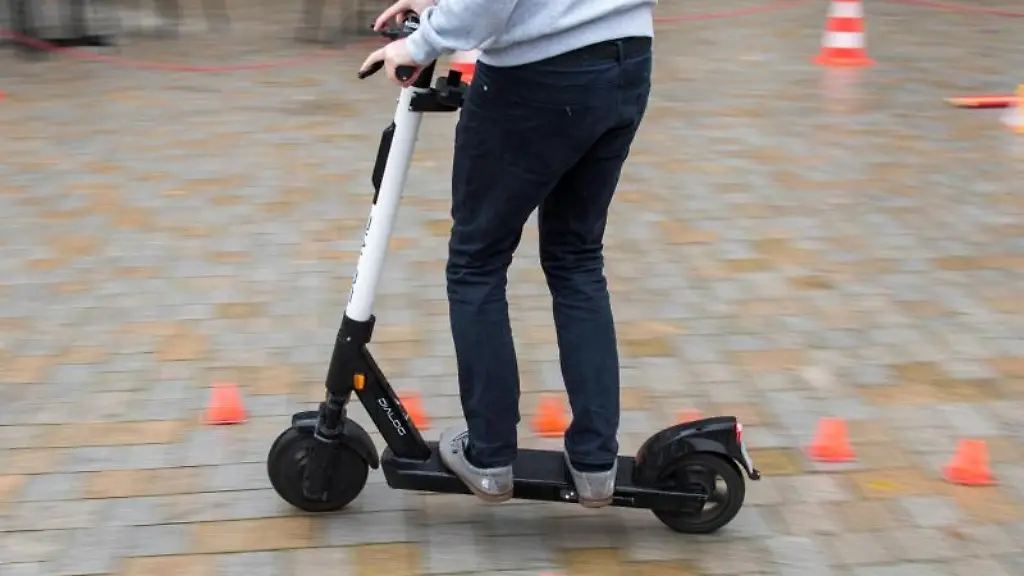 Ein-Mitarbeiter-eines-Anbieters-fuer-E-Scooter-faehrt-waehrend-eines-Fahrsicherheitstrainings-durch-einen-Hindernisparcours