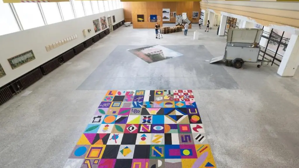 Journalisten-gehen-im-Rahmen-eines-Presserundgangs-durch-die-Ausstellungsraeume-der-Kunstbiennale-Ostrale-2021-in-der-ehemaligen-Kantine-des-DDR-Kombinats-Robotron