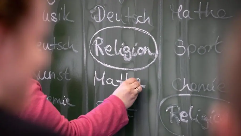 Eine-Lehrerin-schreibt-mit-Kreide-einen-Stundenplan-mit-Religionsunterricht-an-eine-Tafel