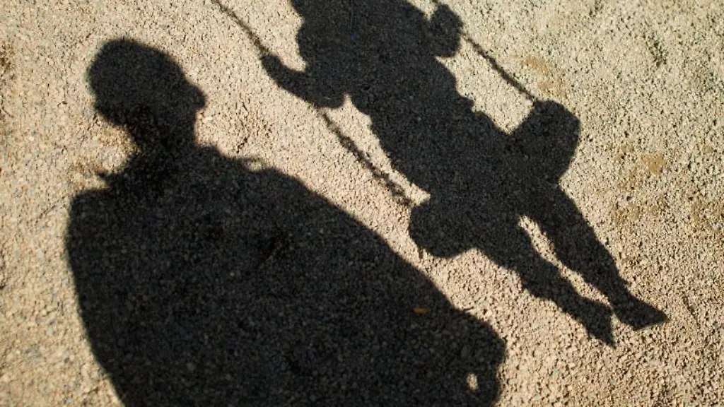 Der-Schatten-von-einem-Mann-und-einem-schaukelnden-Kind