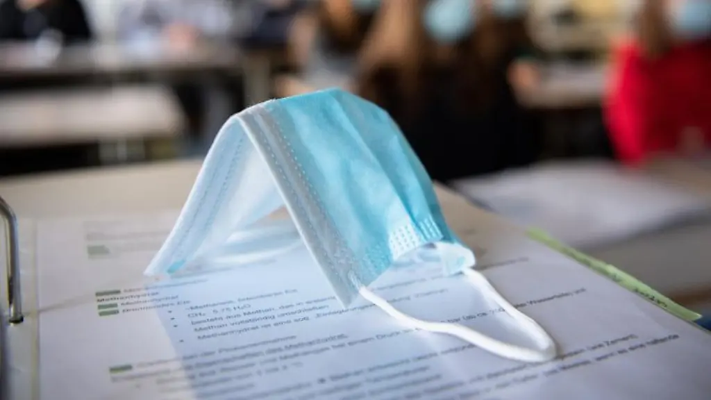 Eine-Medizinische-Maske-liegt-im-Schulunterricht-auf-einem-Tisch