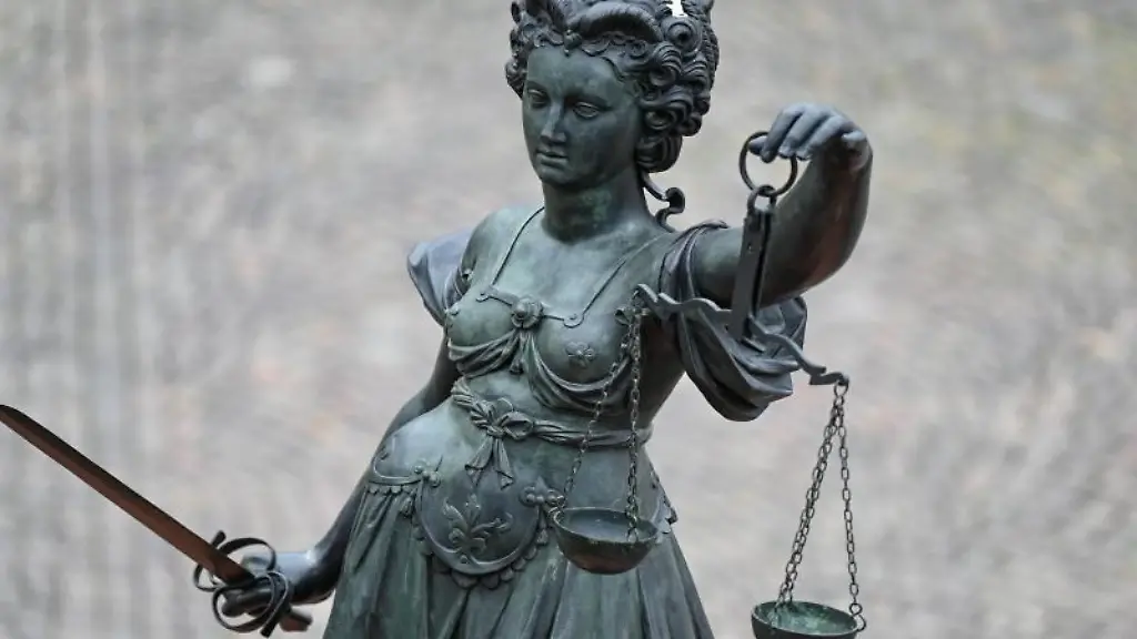 Eine-Statue-der-Justitia-haelt-eine-Waage-und-ein-Schwert-in-der-Hand