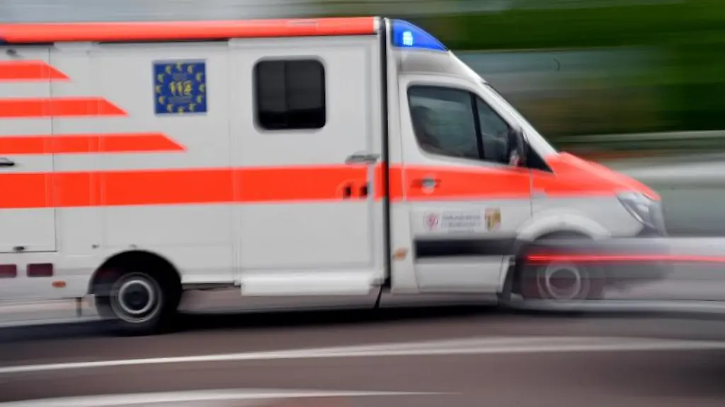 Ein-Krankenwagen-faehrt-mit-Blaulicht-auf-einer-Strasse