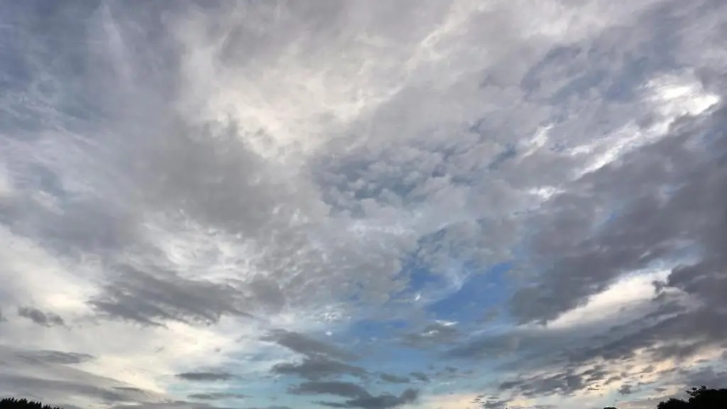 Eine-aufgerissene-Wolkendecke-zieht-ueber-ein-Wiese-hinweg