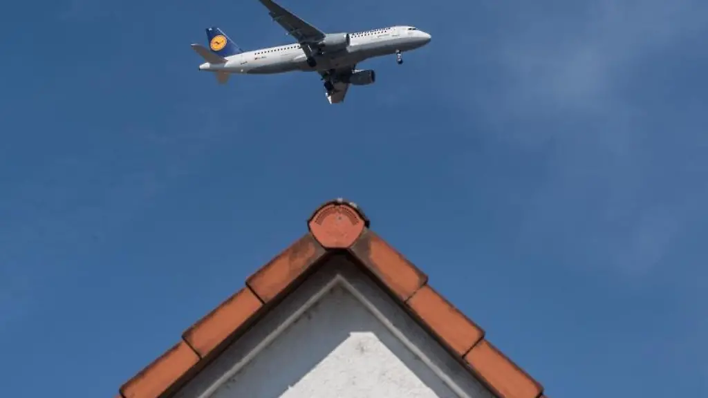 Ueber-den-Daechern-in-Floersheim-am-Main-Hessen-setzt-eine-Passagiermaschine-der-Lufthansa-ihren-Landeanflug-auf-den-Flughafen-Frankfurt-am-Main-fort
