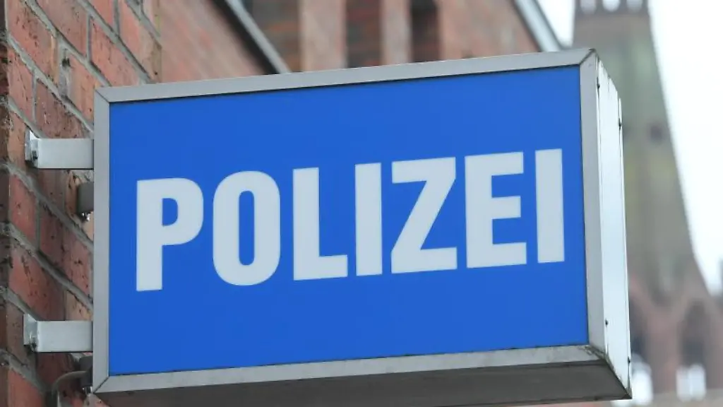 Ein-Schild-mit-dem-Schriftzug-Polizei-haengt-an-einer-Polizeiwache