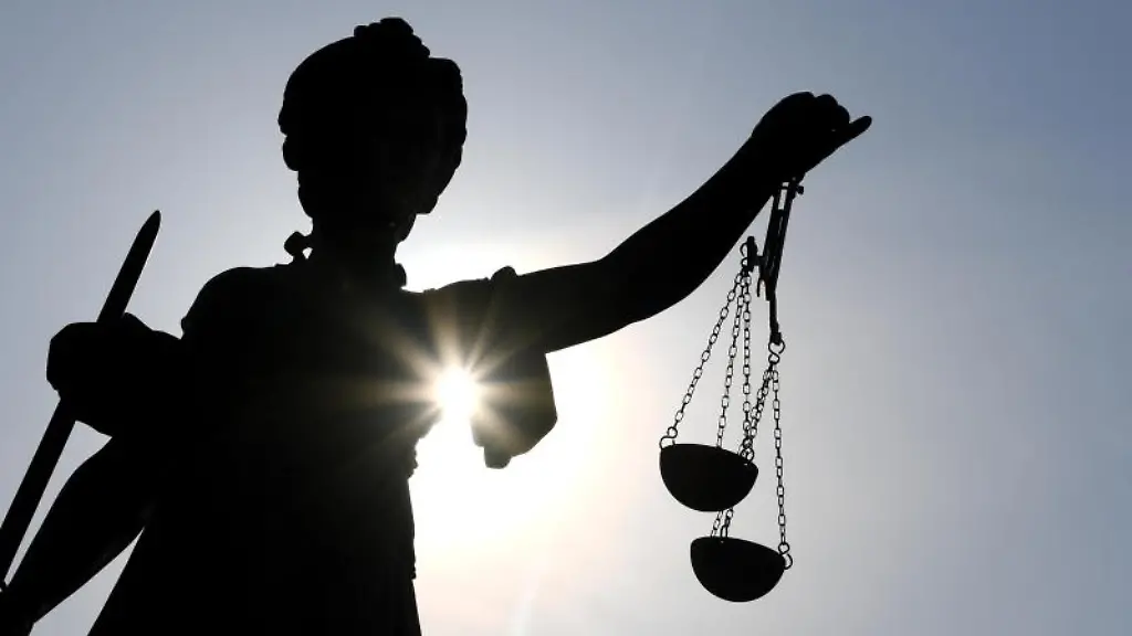 Eine-Statue-der-Justitia-mit-einer-Waage-und-einem-Schwert-in-ihren-Haenden