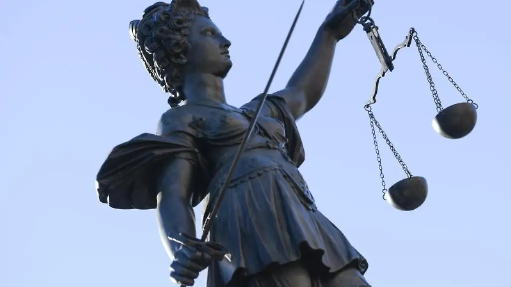 Eine-Statue-der-Justitia-steht-unter-freiem-Himmel
