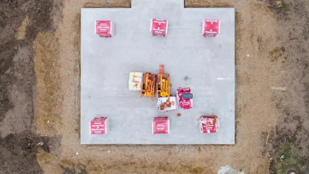 Baumaterial-fuer-ein-Einfamilienhaus-liegt-auf-einer-Bodenplatte