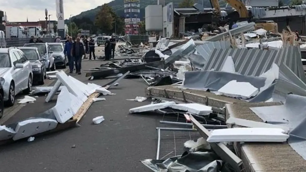 Truemmerteile-einer-eingestuerzten-Betonwand-liegen-auf-einer-Strasse-verteilt