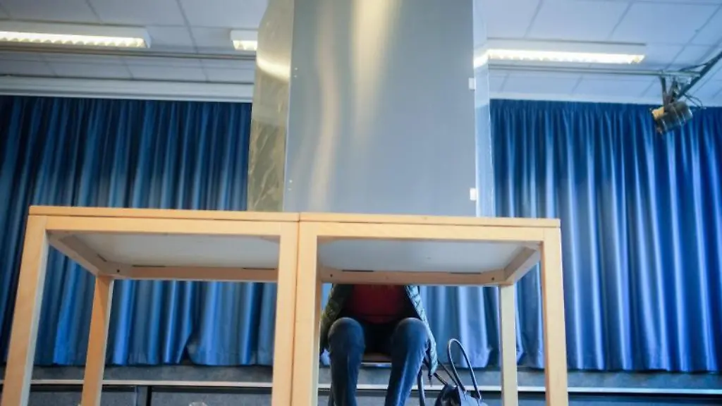 Eine-Waehlerin-sitzt-in-der-Wahlkabine-fuer-die-Bundestagswahl