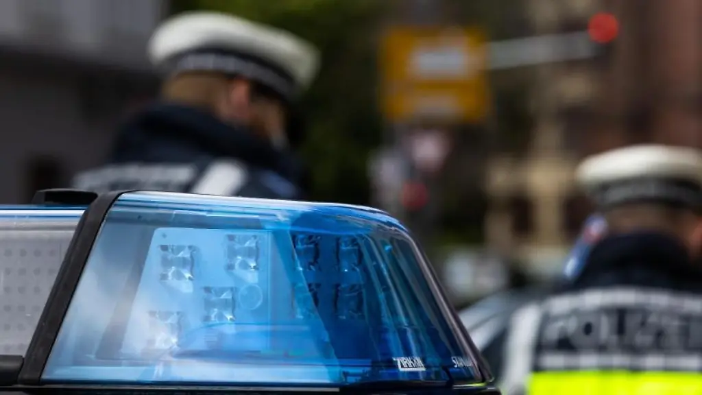 Zwei-Polizeibeamte-stehen-vor-einem-Einsatzwagen