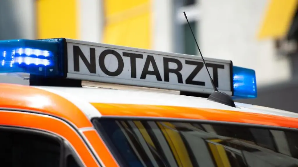 Ein-Notarztwagen-steht-mit-eingeschaltetem-Blaulicht-auf-der-Strasse