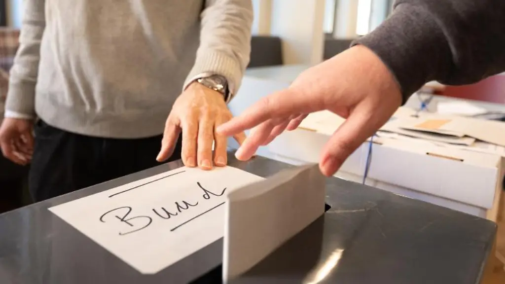 Eine-Frau-wirft-in-einem-Wahllokal-ihren-Wahlzettel-fuer-die-Bundestagswahl-in-eine-Urne