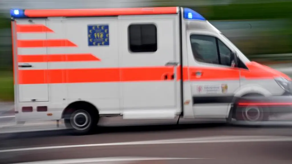 Ein-Krankenwagen-faehrt-mit-Blaulicht-auf-einer-Strasse