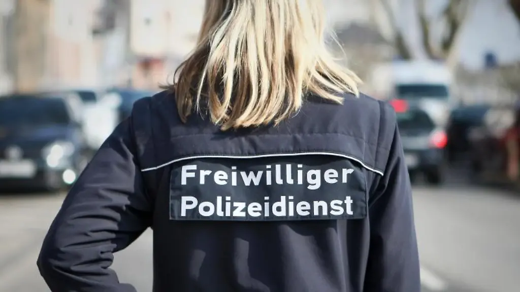 Eine-Frau-mit-dem-Aufdruck-auf-der-Jacke-Freiwilliger-Polizeidienst-regelt-den-Verkehr