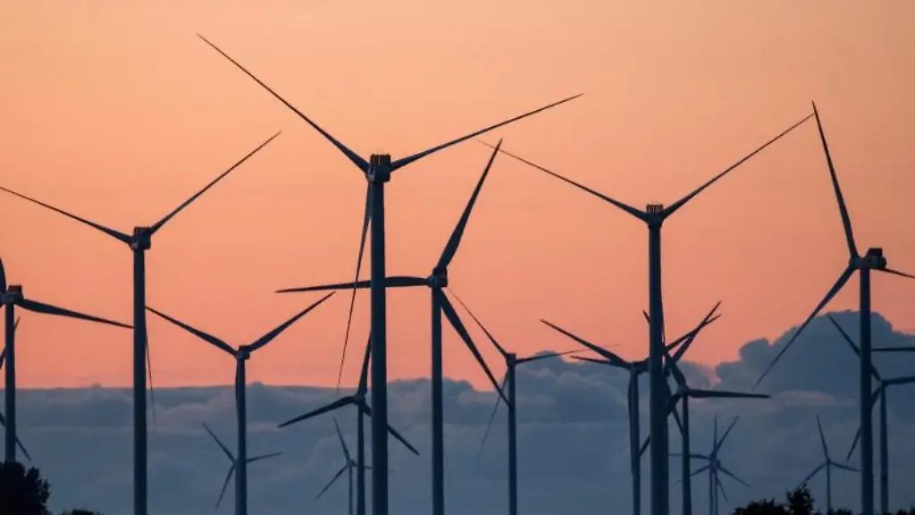 Ein-Windpark-zeichnet-sich-vor-dem-im-Abendlicht-leuchtenden-Himmel-ab