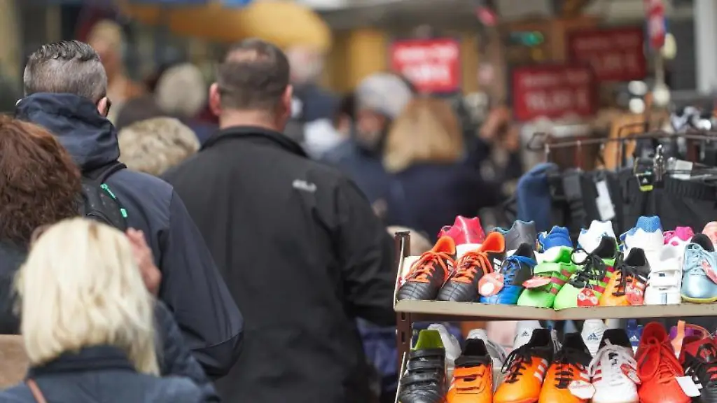 Fussgaenger-gehen-durch-die-Stadt-an-geoeffneten-Laeden-vorbei